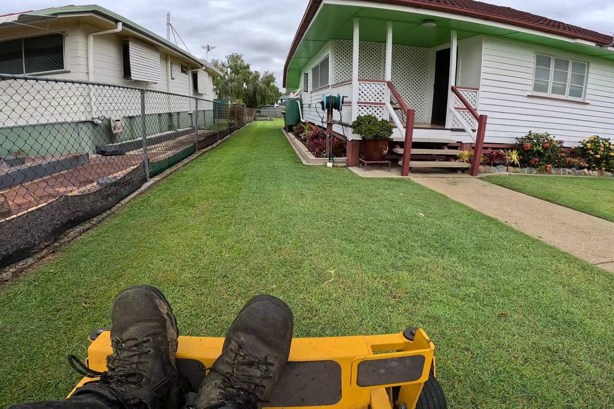 Ride-on mowing beside a home